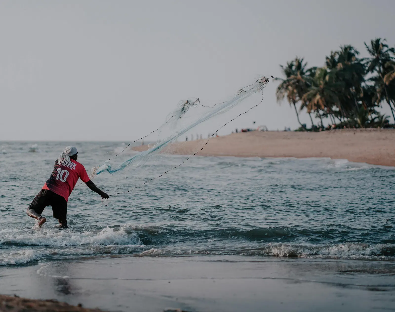 A man throwing net in the beach at Kollam.